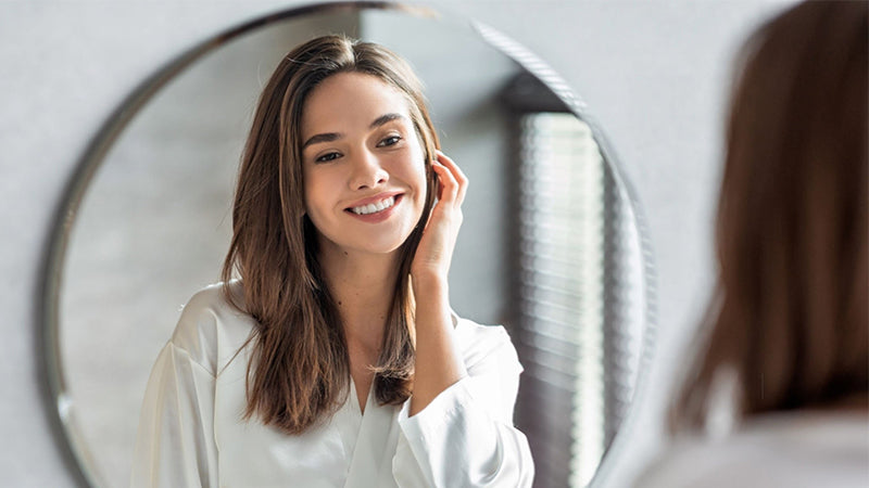 Lady is watching herself in front of mirror as she is quite happy 