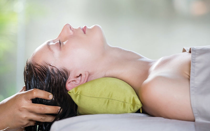 lady is having scalp massage by masseuse 
