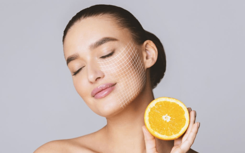 Girl is showing half orange while smiling 