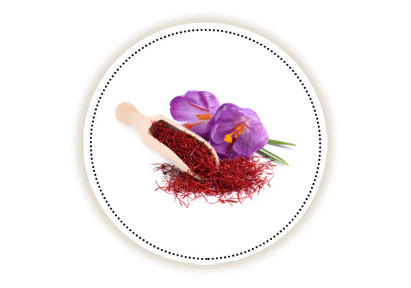 Saffron on a wooden spoon with a purple crocus flower on a white background.