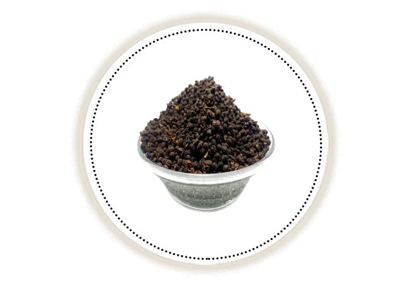 Small bowl filled with dark seeds on white background